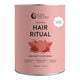 A pink cylindrical tin of Nutra Naturals Hair Ritual powder, featuring a pomegranate illustration on the label, set against a plain white background.