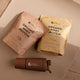 Two packages of Nutra Organics Organic Whey Protein range & a shaker bottle on a wooden surface.