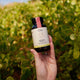 Hand holding jar of Ora Adrenal Tonic+ 60 capsules, vegan supplement that relieves symptoms of stress, mild anxiety, and fatigue.