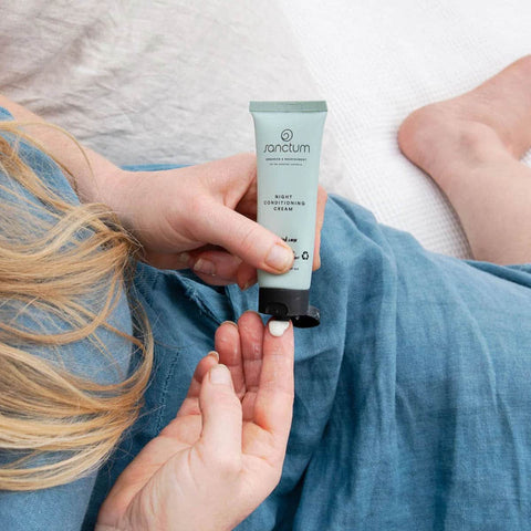 Person applying sanctum night cream to their hand.