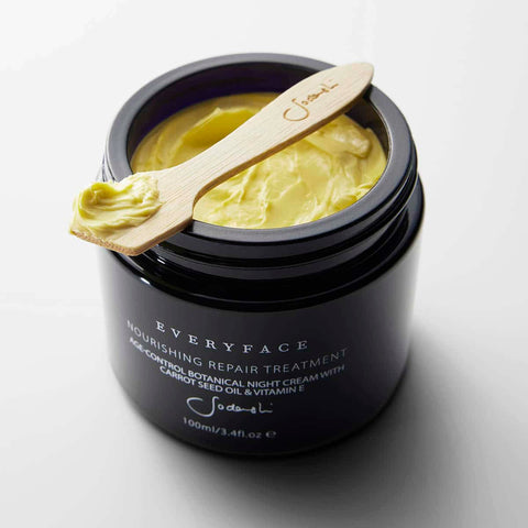 Black jar of 'Everyface' nourishing repair treatment with a wooden applicator on a white background.
