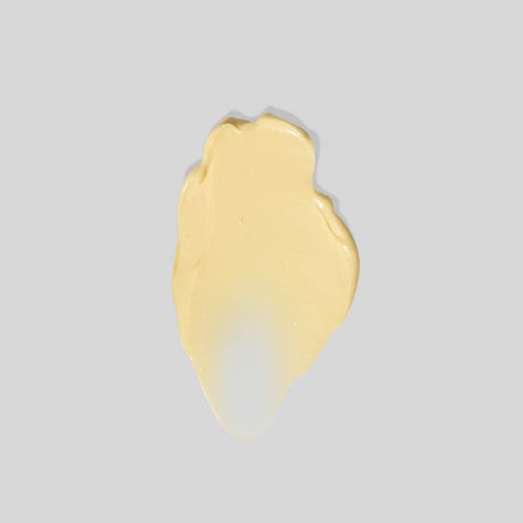 Yellow creamy swatch on a grey background.