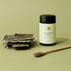 Eucumbia bark and a container of Eucommia bark powder on a green background.
