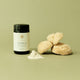 Supplement bottle labeled 'Tremella' with sponges and powder on a green background