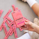 Person holding a pink 'switch' creatine supplement box with multiple packets on a gray surface.