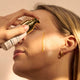 Person applying The Jojoba Company Pigmentation Oil product to their face with a dropper.
