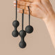 Hand holding The Natural Love Company Amyris, 3 black Kegal balls.