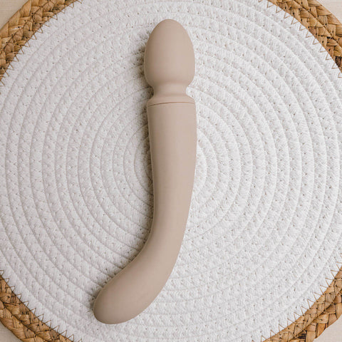 The Natural Love Company Cassia, a dual-ended marvel with a deeply rumbly wand vibrator on one end paired with a G-spot targeting dildo on the other, all encased in buttery soft pastel pink silicone.