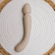 The Natural Love Company Cassia, a dual-ended marvel with a deeply rumbly wand vibrator on one end paired with a G-spot targeting dildo on the other, all encased in buttery soft pastel pink silicone.