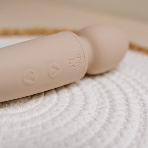 The Natural Love Company Cassia, a dual-ended marvel with a deeply rumbly wand vibrator on one end paired with a G-spot targeting dildo on the other, all encased in buttery soft pastel pink silicone.
