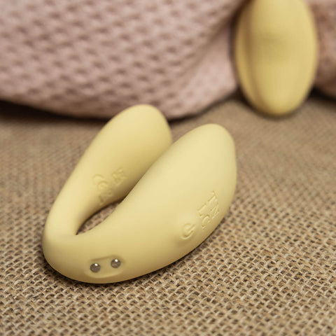 The Natural Love Company Cistus, a remote controlled (remote included) U-shaped vibrator with dual vibrating motors (one at each end), it's crafted with a recycled ocean plastic internal body dressed in a buttery smooth silicone casing, which comes in a creamy yellow hue.