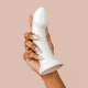 Hand holding The Natural Love Company Dill G-Curve, a silicone dildo with 6 inches of insertable length and girth of 5 inches at its thickest insertable point.