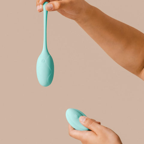 Hand holding The Natural Love Company Nepeta, a remote controlled love egg with strong vibrations.