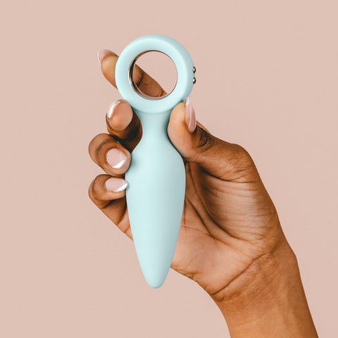 Hand holding The Natural Love Company Quince, a vibrating butt plug.
