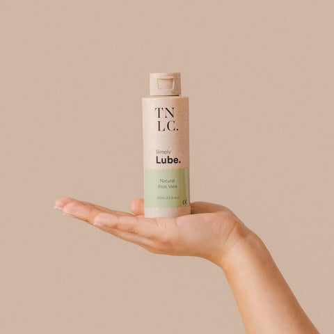 Hand holding The Natural Love Company Simply Lube - Natural Aloe Vera, a water-based lubricant only using natural ingredients.