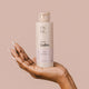 Hand holding The Natural Love Company Simply Lube - Wild Strawberry, a water-based lubricant only using natural ingredients.