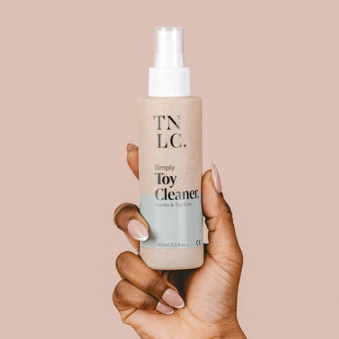 Hand holding The Natural Love Company Simply Toy Cleaner, a gentle and toy safe water-based sex toy cleaner.