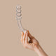 Hand holding The Natural Love Company Tansy G Curve, a 7 inch glass dildo.