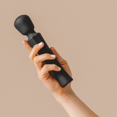 Hand holding The Natural Love Company Tulsi, a powerful wand vibrator.