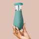 Hand holding The Natural Love Company Verbana, a clitoral suction, licking, and vibration sex toy.