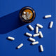 Theronomic Tribiotic Gut Shield jar and capsule on a blue background, pre, pro, and postbiotic supplement.
