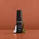 Three Warriors Self-Tan Mousse styled with coconut pieces and aloe vera leaves against an orange background.