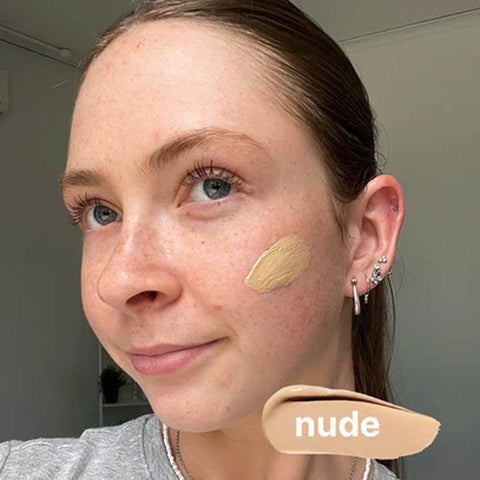 Woman with a nude bb cream swatch on her face.